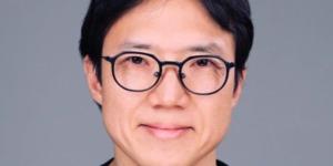 David Hahn - Asian man with black hair and black rimmed glasses smiling at the camera